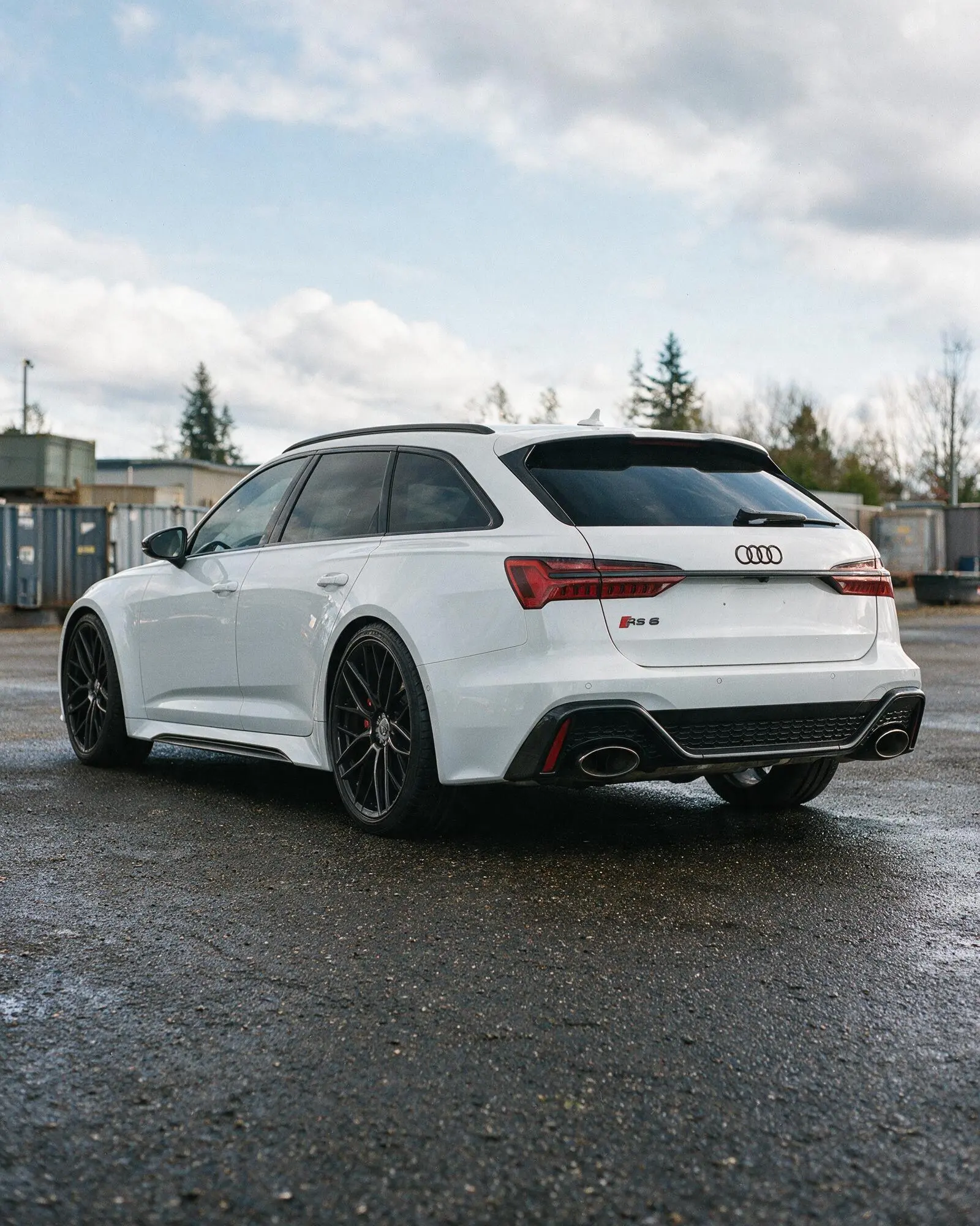 Audi RS6 Avant photographed from the rear three-quarter angle on a wet road